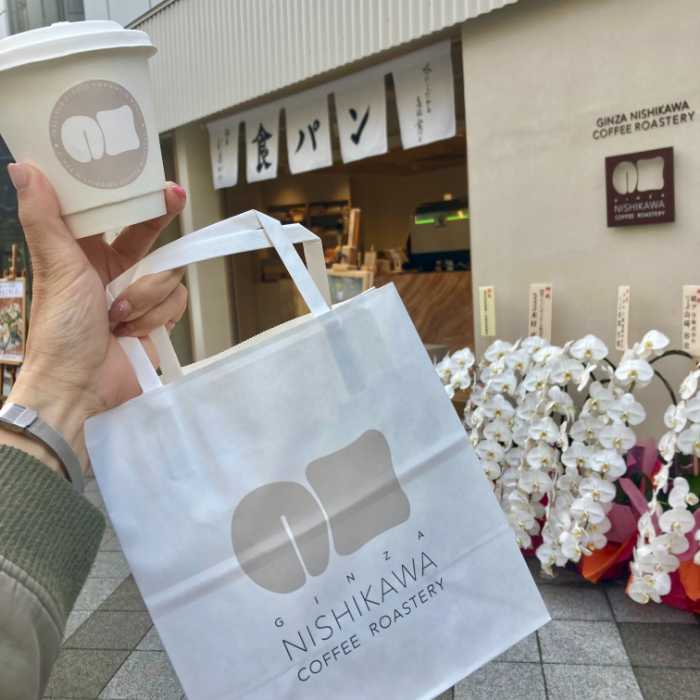 GINZA NISHIKAWA COFFEE ROASTERY 食パンカフェスタンド 三田慶應大前店の外観とテイクアウトショッパー、ドリンク